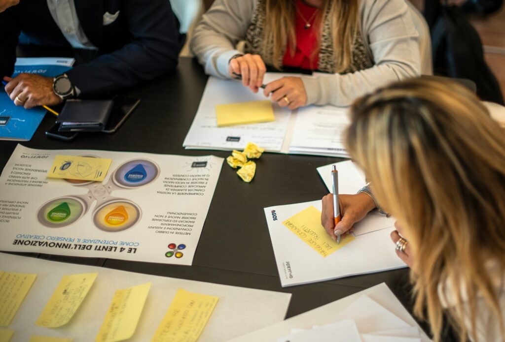 a group of people sitting around a table with papers