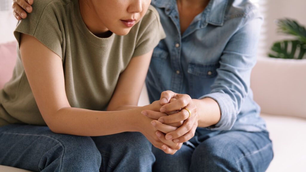 Woman and mentor comforting and safeguarding a child.