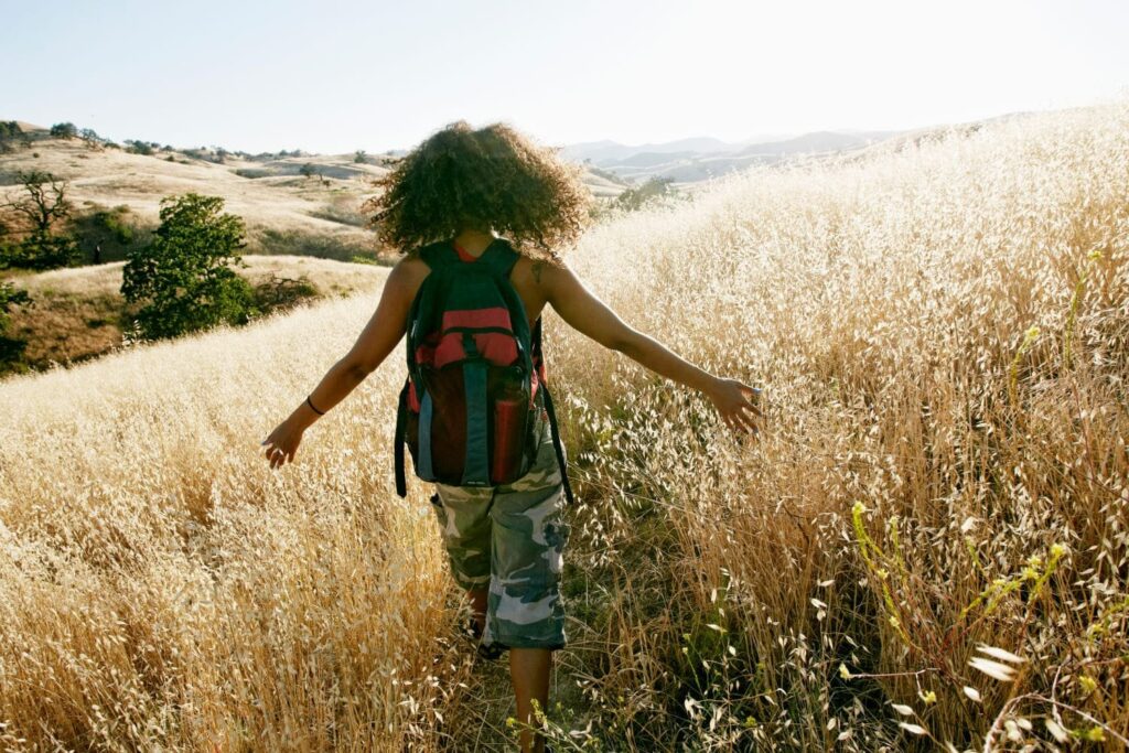 A woman in a field for exercise for self care