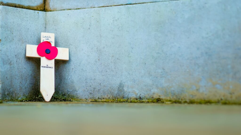 a white cross with a red flower on it