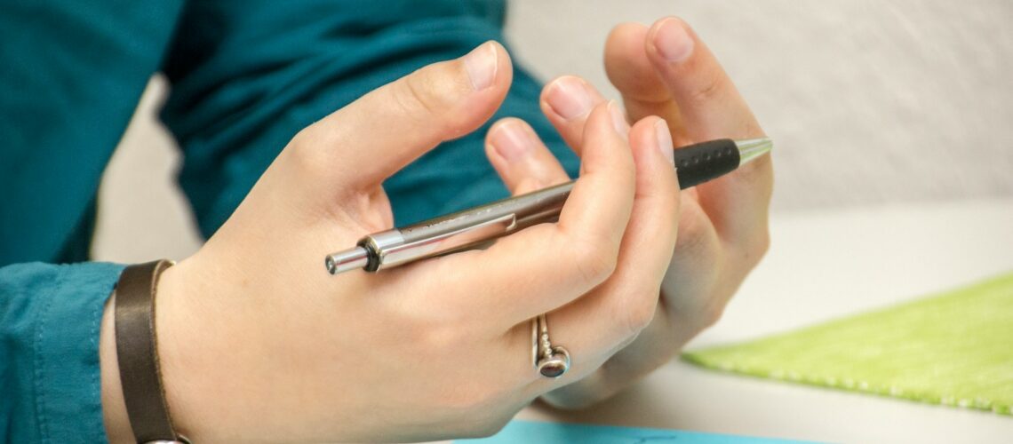 a person sitting at a table using a cell phone
