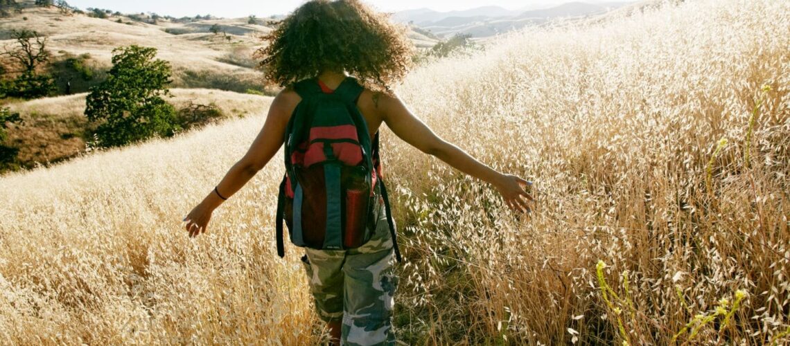 A woman in a field for exercise for self care